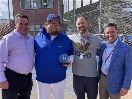 Honoree, Superintendent, Principal and Athletic Director smile together holding award